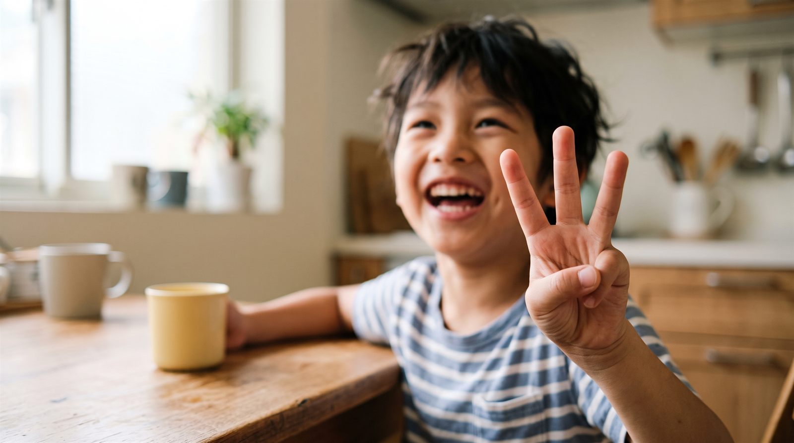 孩子在餐桌前用手指數數，一邊學習日文數字的唸法