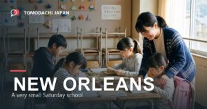 A very small Saturday community classroom with four children of different ages sharing one table with a single Japanese teacher