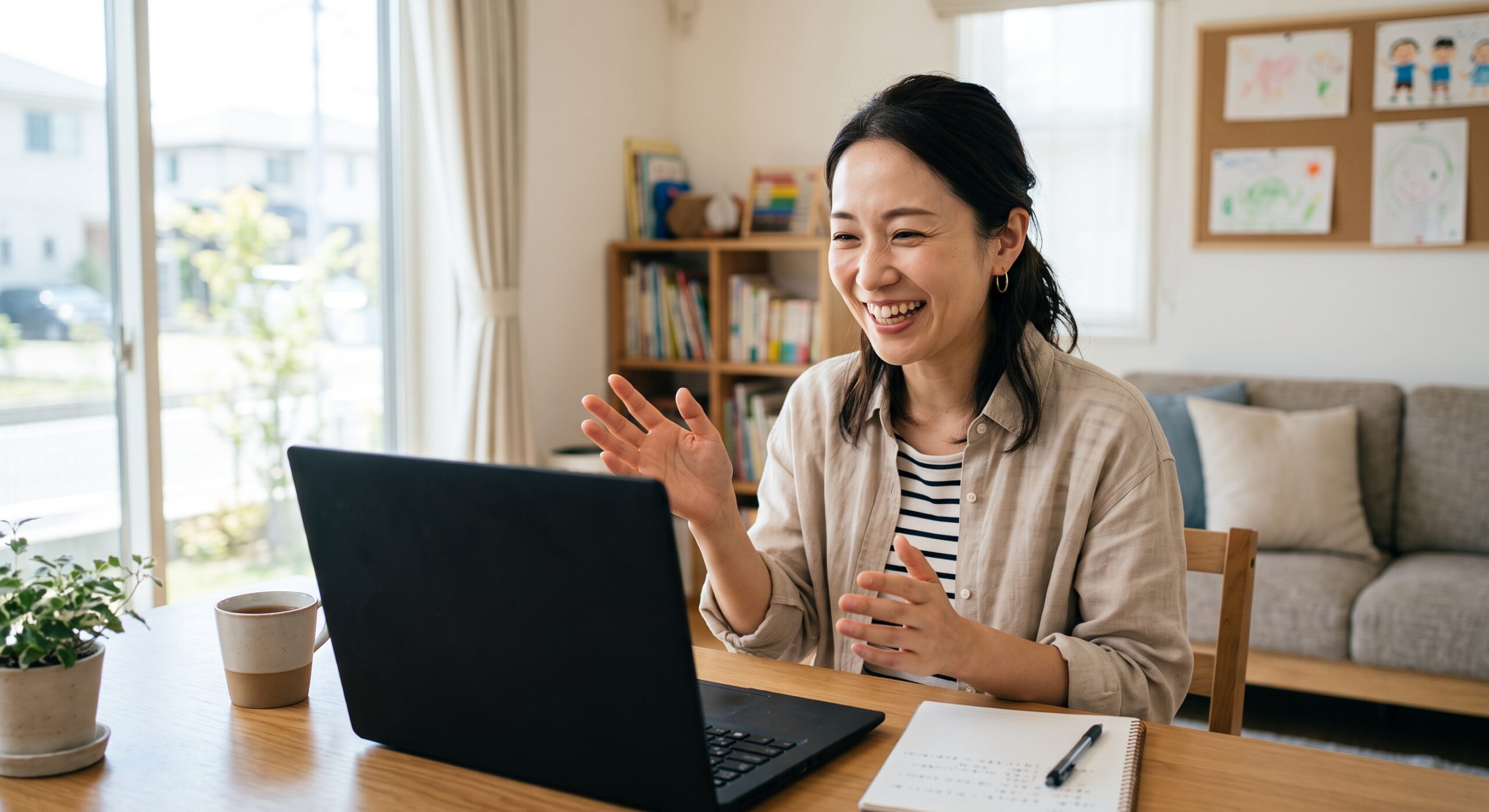 オンライン授業の画面に向かって笑顔で身ぶりを交えながら話している日本人女性の先生