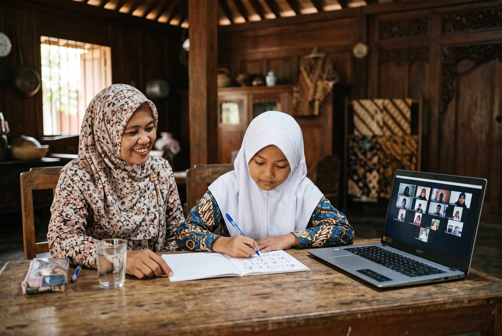 Anak perempuan di Solo belajar menulis hiragana bersama ibunya sambil mengikuti kelas bahasa Jepang online